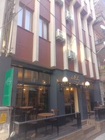 A building with a sign for 'Lehbery Hotel' and a visible outdoor seating area with tables and chairs.