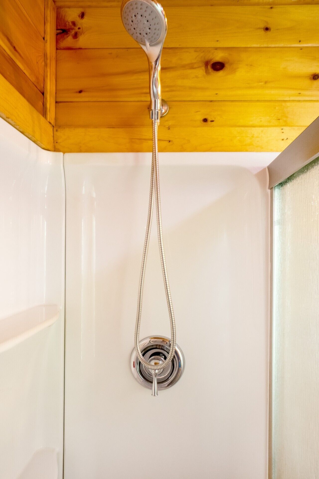 A shower with a handheld showerhead and a flexible hose.