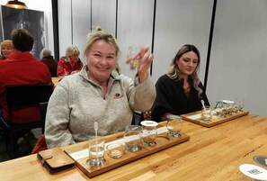 A tasting event with a wooden table displaying various glasses and a tray. - Buffalo Springs Distilling Company (Stamping Ground)