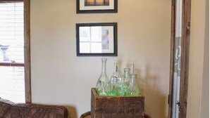 Une pièce comprenant un tonneau en bois, un canapé et deux tableaux encadrés accrochés au mur.