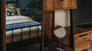 Ein Schlafzimmer mit Bett, Nachttisch, Spiegel und Kommode.