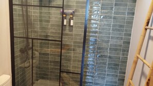 A bathroom with a glass-enclosed shower, a toilet, and a wooden floor. - House with pool ribadavia (Francelos)