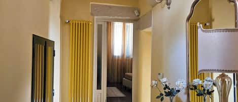A room with a wooden dresser, a mirror, and a door leading to another room.