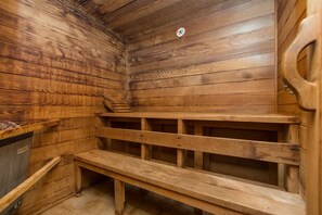 Un sauna avec des bancs en bois et un mur en bois.