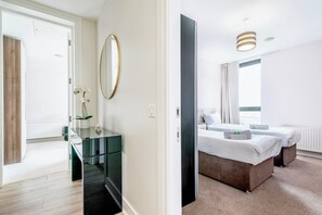 Ein Hotelzimmer mit Bett, Nachttischen, einem Spiegel und Meerblick.