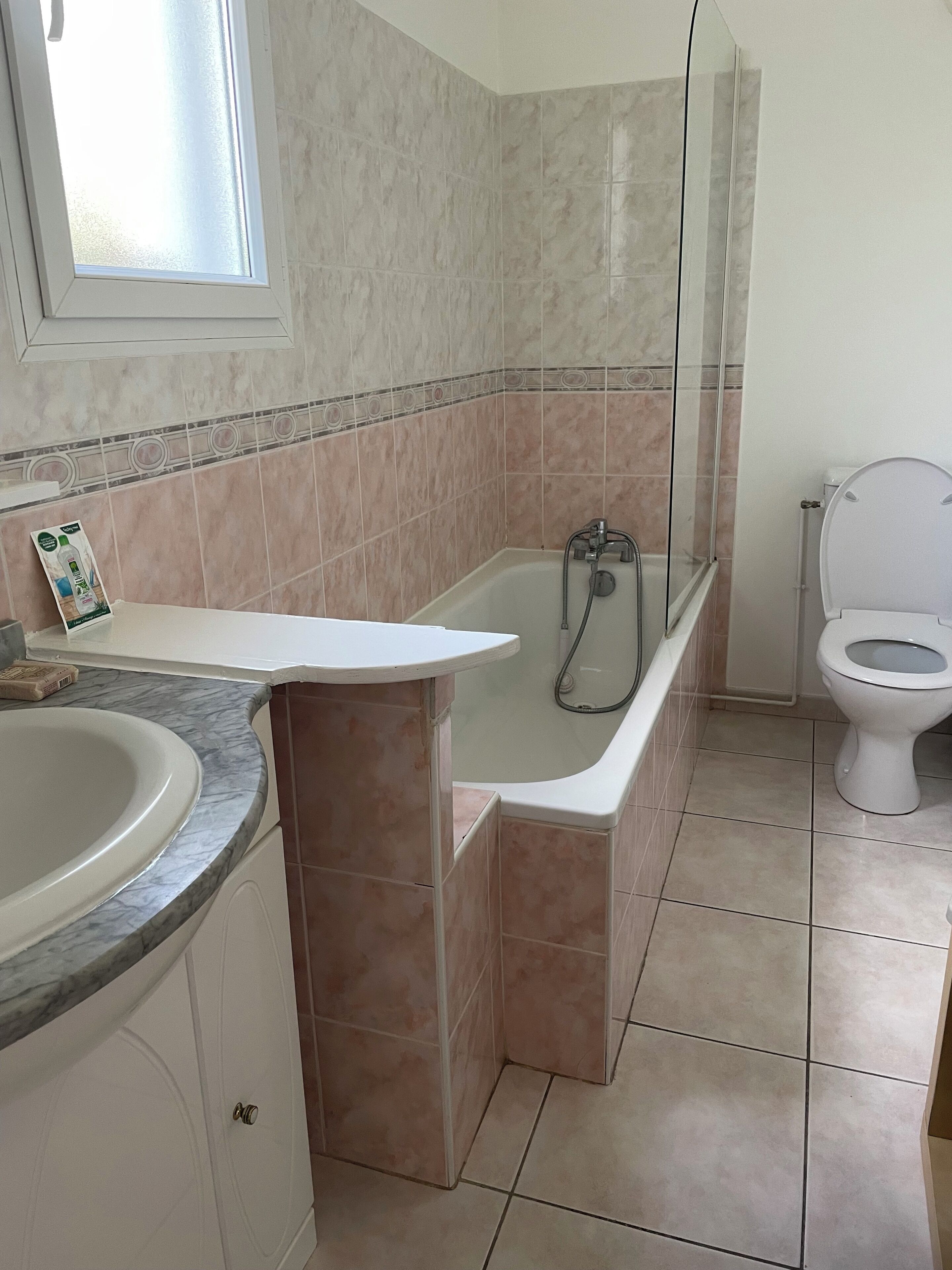 A bathroom with a bathtub, toilet, and sink.