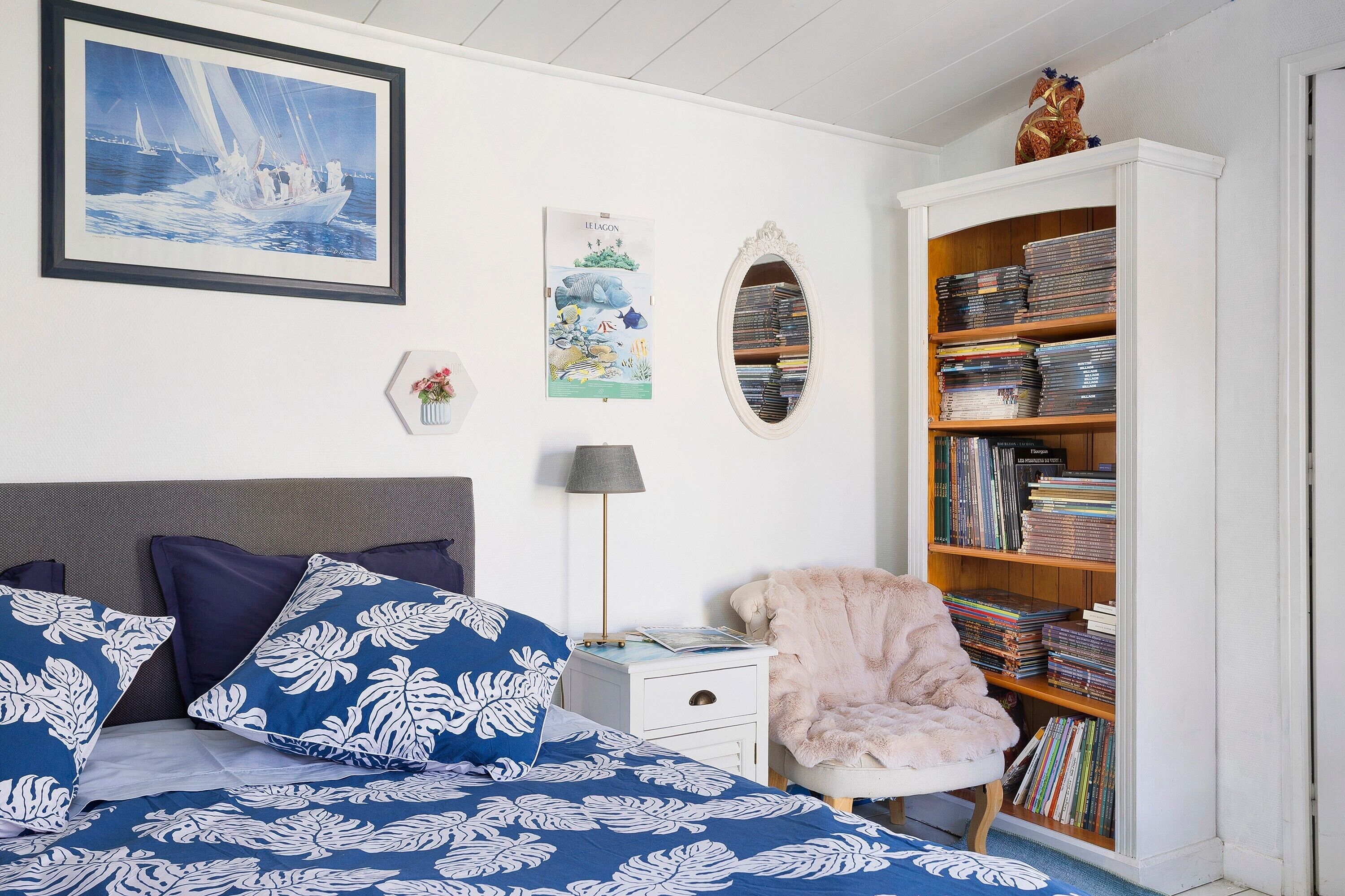 Un dormitorio con una cama, una estantería, un escritorio y una silla.