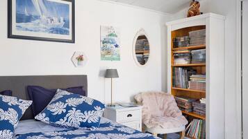 Un dormitorio con una cama, una estantería, un escritorio y una silla.