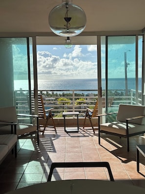 A balcony with a view of the sea, a table, and two chairs. - TheTimeless Haven PR@ Oceanfront Escape- Maunabo (Maunabo)