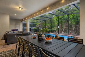 A covered outdoor dining area with a pool view, a bar, and outdoor seating. - NEW! Star Wars Galactic Landing - Minutes to Disney World! Pool, Hot tub, Themed (Kissimmee)