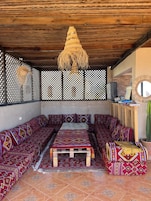 Una habitación acogedora con un sofá grande, una mesita y una lámpara colgante.