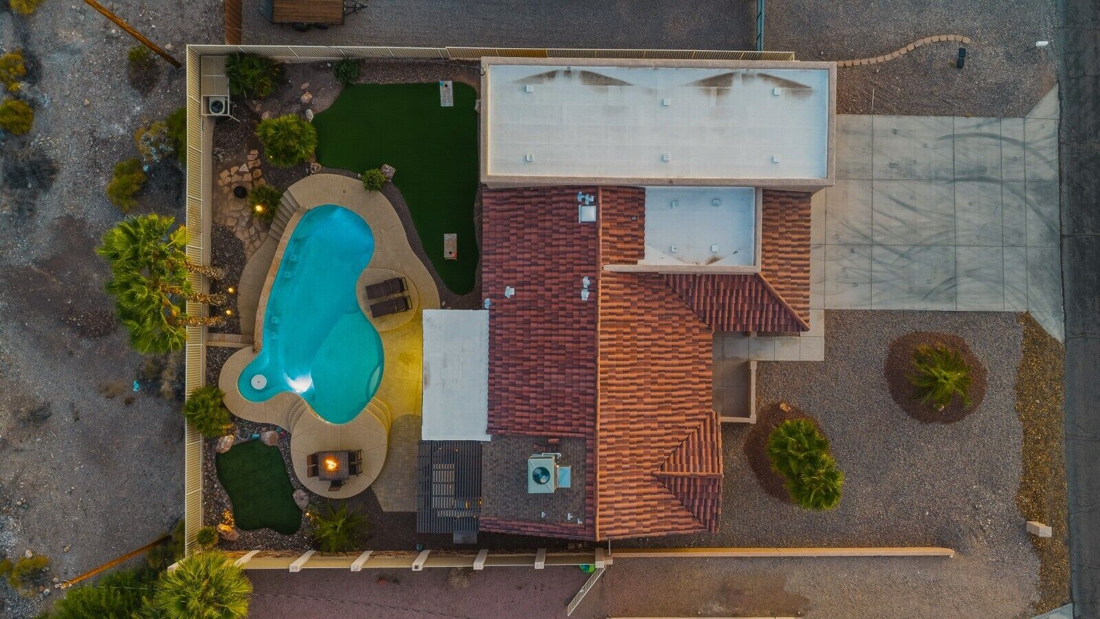 Vue aérienne d’une propriété dotée d’une piscine, d’un espace salon extérieur et d’une terrasse couverte.