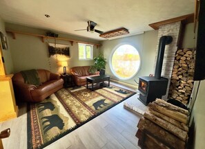 A cozy living room with a fireplace, leather sofa, coffee table, and a rug with animal prints.
