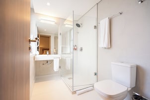 Un bagno moderno con doccia vetro, servizi igienici e lavandino con portasciugamani.
