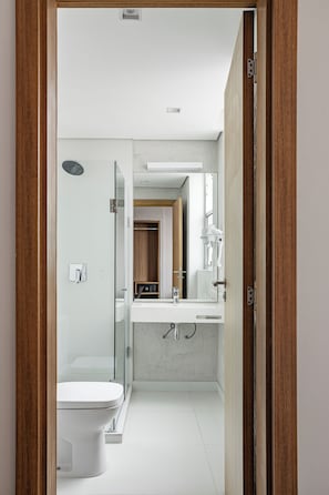 A modern bathroom with a toilet, shower, and sink. - Hotel Moov São Paulo (São Paulo)
