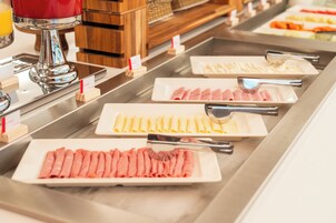 Buffet com diversos alimentos e utensílios.