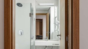 Une salle de bain moderne avec une douche à parois de verre, des toilettes et un lavabo avec un miroir.