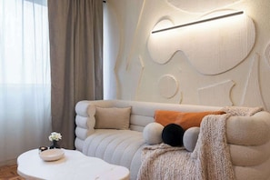 A modern living room with a sofa, a coffee table, and a wall with a unique light fixture. - Mexican 2BR - 2Bath of Condesa - Wifi High Speed (Mexico City)