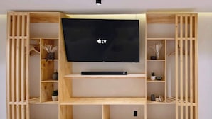 Et træunderholdningsmøbel med et fladskærms-tv, hylder og opbevaringsrum.