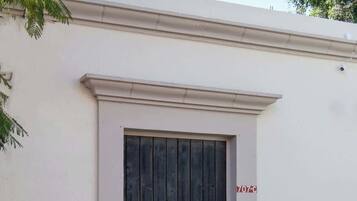 A building with a large black door, a white wall, and a small sign with '707-C'.