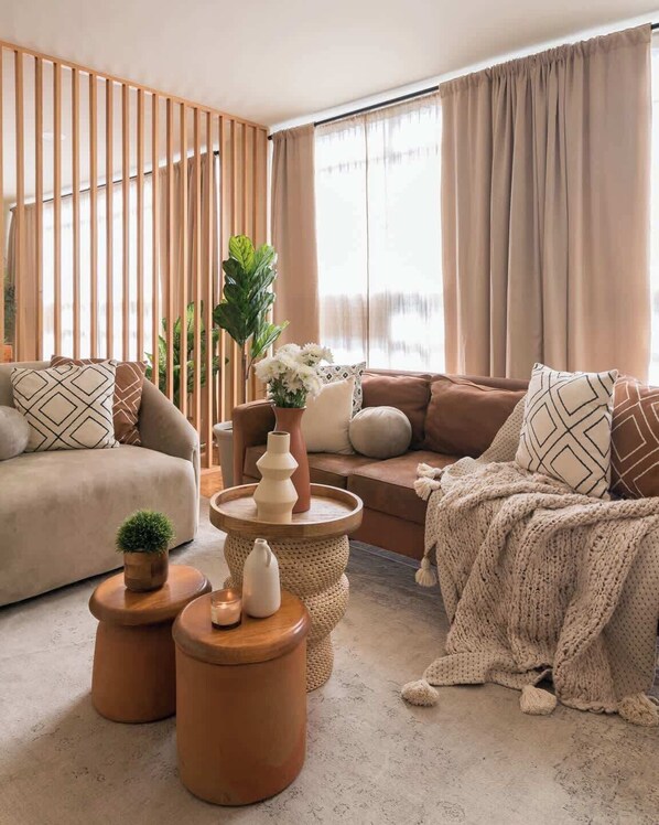A modern living room with a sofa, two side tables, a coffee table, and a decorative plant. - Chic Stylish Design Flat in Roma Norte Prime Area (Mexico City)