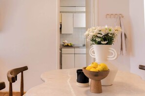 A dining area with a table, chairs, a vase with flowers, a bowl of lemons, and a coffee cup. - Location- Design And Comfort Fully equipped (Ciudad de México)