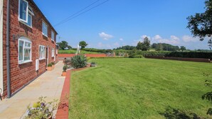 A brick house with a well-maintained lawn and a gated entrance. - Fron-haul (Llansantffraid-ym-Mechain)