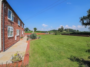 A brick house with a well-maintained lawn and a gated entrance.