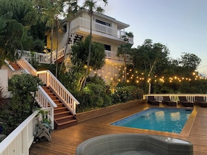 A swimming pool with a wooden deck, a staircase, and a balcony. - The Breeze (ST Thomas)