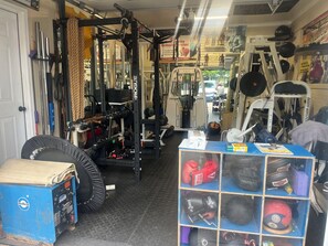 Ein Fitnessstudio mit Gewichthebersportgeräten, Laufbändern und einem Boxring.