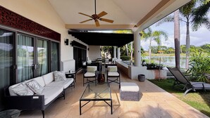 A covered outdoor seating area with a ceiling fan, a sofa, chairs, and a table. - Splendid 4BR Villa at Buenaventura Resort (Río Hato)