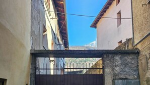 A gated courtyard with a metal gate, stone steps, and a utility box on the wall. - VICOLO STORICO Room - Grandfather Angelo's HOUSE (Capo di Ponte)