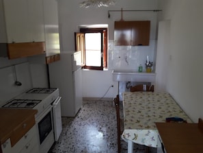 Une petite cuisine équipée d’une cuisinière à gaz, d’un four et d’une fenêtre donnant sur un beau paysage.