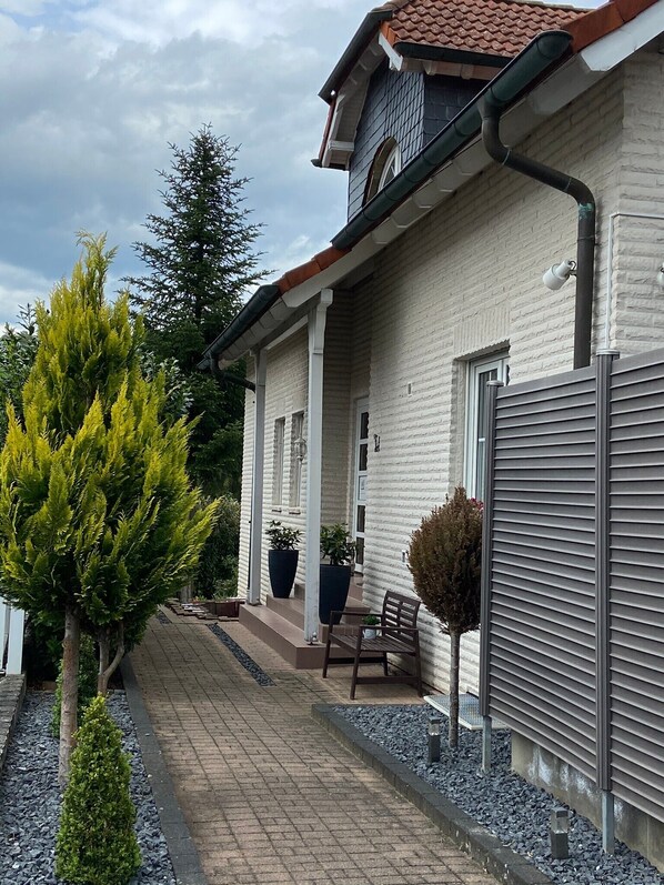 A house with a brick exterior, a covered porch, and a gravel pathway. - 104 m² bright, high-quality apartment with 2 balconies by the forest near Linz (Linz am Rhein)