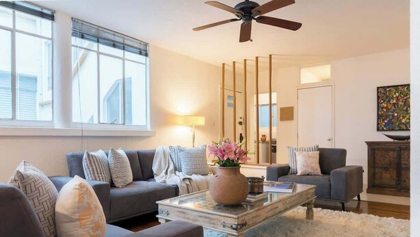 Ein Wohnzimmer mit Sofa, Couchtisch und Deckenventilator.