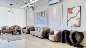 A modern living room with a sofa set, a coffee table, and a console table with a vase. - LAVIN SUITES SERVICED APARTMENTS  (At Taif)