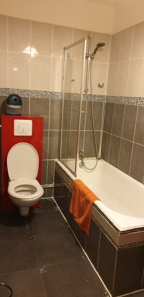 Ein Badezimmer mit Toilette, Dusche und Badewanne.