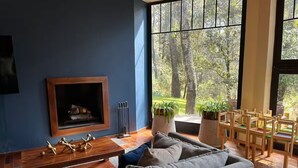 A living room with a fireplace, a sofa, a coffee table, and a dining area with chairs and tables. - CABAÑA RANCHO SAN FRANCISCO TAPALPA (Tapalpa)