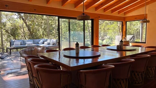 A spacious dining area with a large wooden table, multiple chairs, and a sofa with cushions. - CABAÑA RANCHO SAN FRANCISCO TAPALPA (Tapalpa)