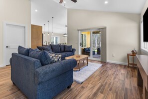 A modern living room with a sofa, coffee table, and wooden flooring. - The Retreat at Seal Point-New! (Lamoine)