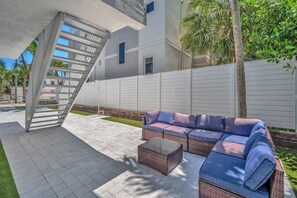 A modern outdoor patio with a wicker sofa, a glass coffee table, and a metal staircase. - #2 - Beachside Studio  Steps to Hollywood Beach (Hollywood)