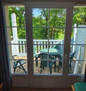 A room with a sliding glass door leading to an outdoor patio with a table and chairs.