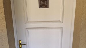 Una puerta blanca con manija de latón y una placa con el número de la casa.
