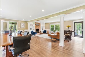 A spacious living area with a fireplace, a dining table, and comfortable seating.