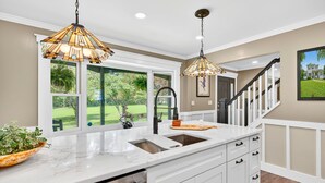 A kitchen with a large island, double sink, and pendant lighting. - Modern Farmhouse: 12.5 Acres & 2 Fire Pits (Lothian)