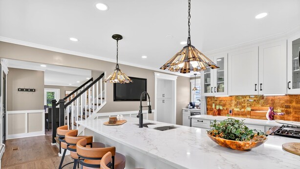 A modern kitchen with a marble island, bar stools, pendant lights, and a large window. - Modern Farmhouse: 12.5 Acres & 2 Fire Pits (Lothian)