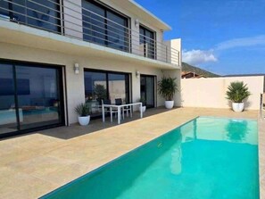 A modern two-story house with a swimming pool, outdoor seating, and potted plants. - MAGNIFICENT VILLA WITH POOL, SPA AND SEA VIEW (Cerbère)