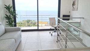 A modern living room with a large sliding glass door leading to a balcony with a sea view. - MAGNIFICENT VILLA WITH POOL, SPA AND SEA VIEW (Cerbère)
