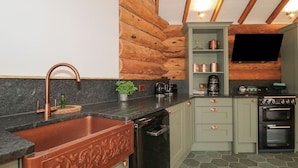 A kitchen with a copper sink, a dishwasher, a stove, and a microwave.