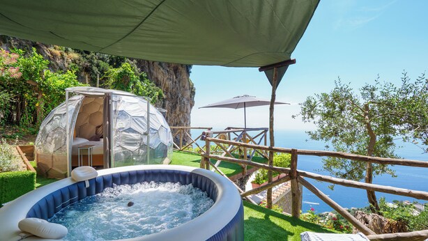 A hot tub, a glass igloo, and a wooden deck overlooking a cliff and sea. - De Vivo Realty - Boscosfera Amalfi (Amalfi)